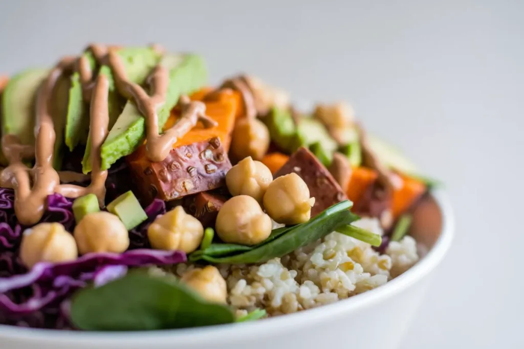 A colorful Vegan Buddha Bowl filled with quinoa, roasted vegetables, avocado, and a tahini dressing.