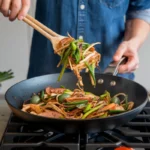 Vegetables and meat stir-frying in a wok on high heat